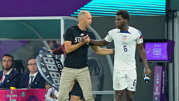 USA manager Gregg Berhalter talks with midfielder Yunus Musah.